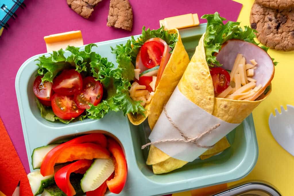 Schul Catering – Bunte Lunchbox mit Wraps und Gemüse